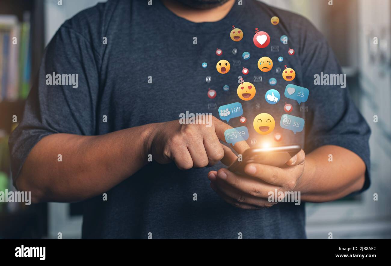 Hands holding and typing to communicate with others through emoji emotion. Online social communication,Social media,emotion, hearts. Chat Conversation Stock Photo