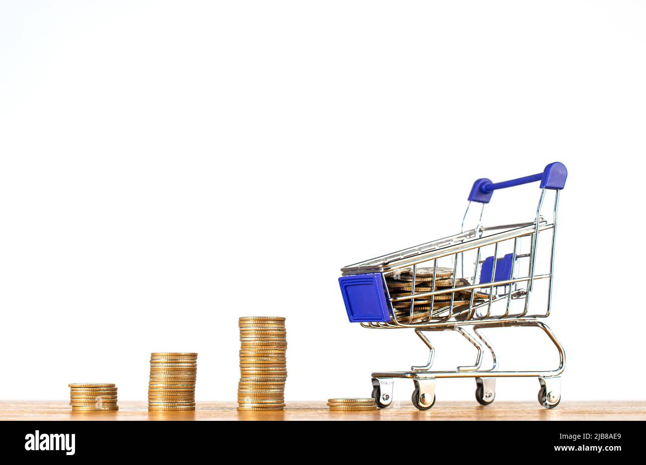 Stack coin with shopping cart or trolley, Excessive shopping causes financial problems, lavish spending. Online shopping and e-commerce concept. Stock Photo