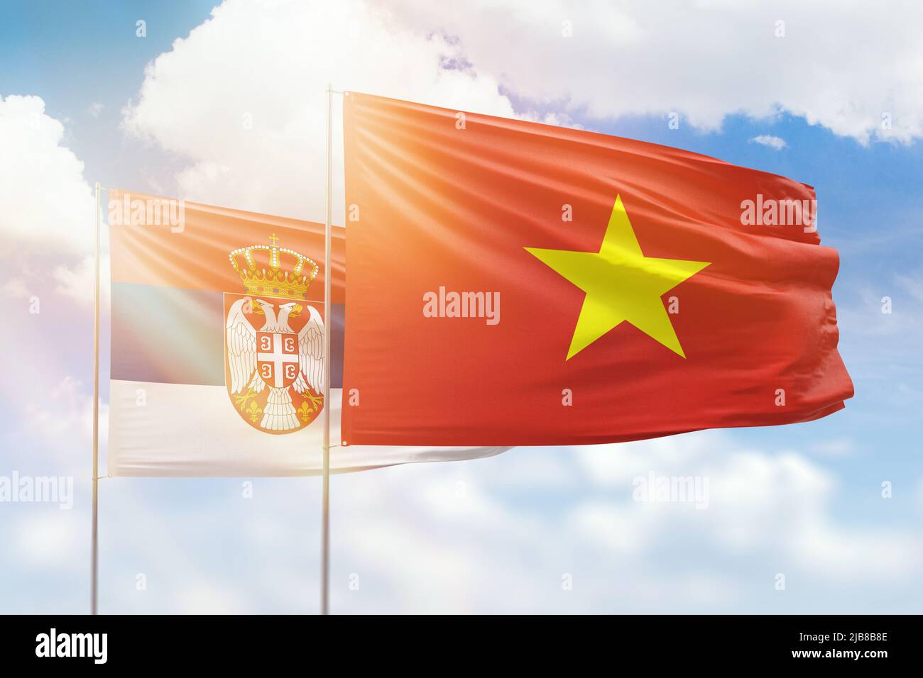 Sunny blue sky and flags of vietnam and serbia Stock Photo Alamy