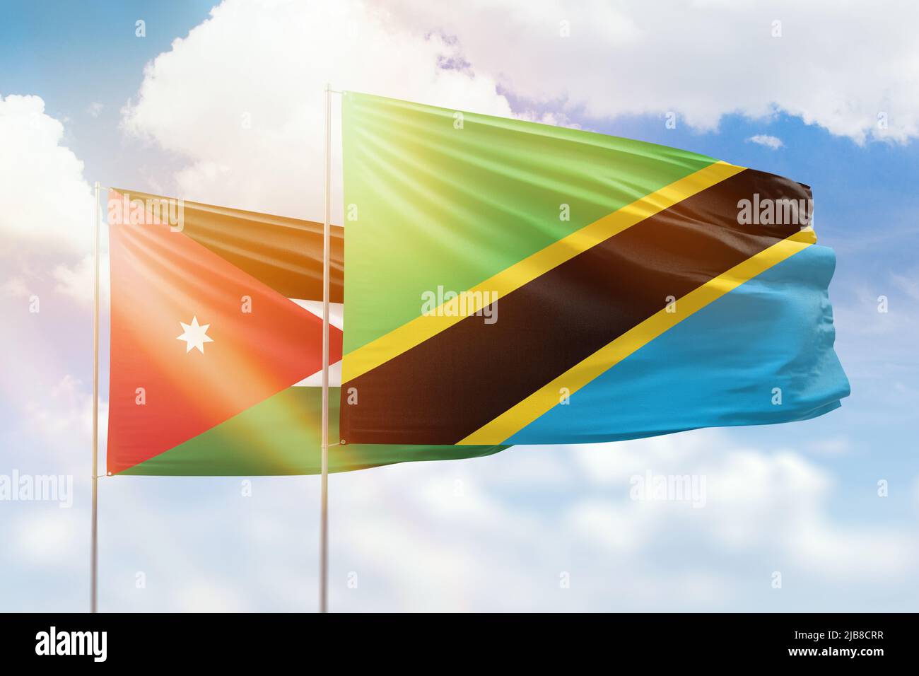 Sunny blue sky and flags of tanzania and jordan Stock Photo