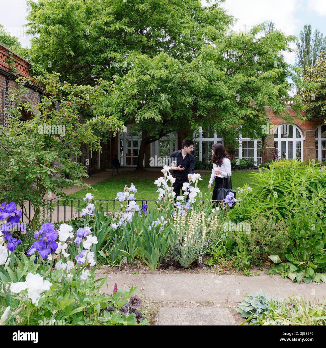 London, Greater London, England, May 28 2022: Couple look at the flowers in the Lawned garden with Orangery at Holland Park in the Kensington area. Stock Photo