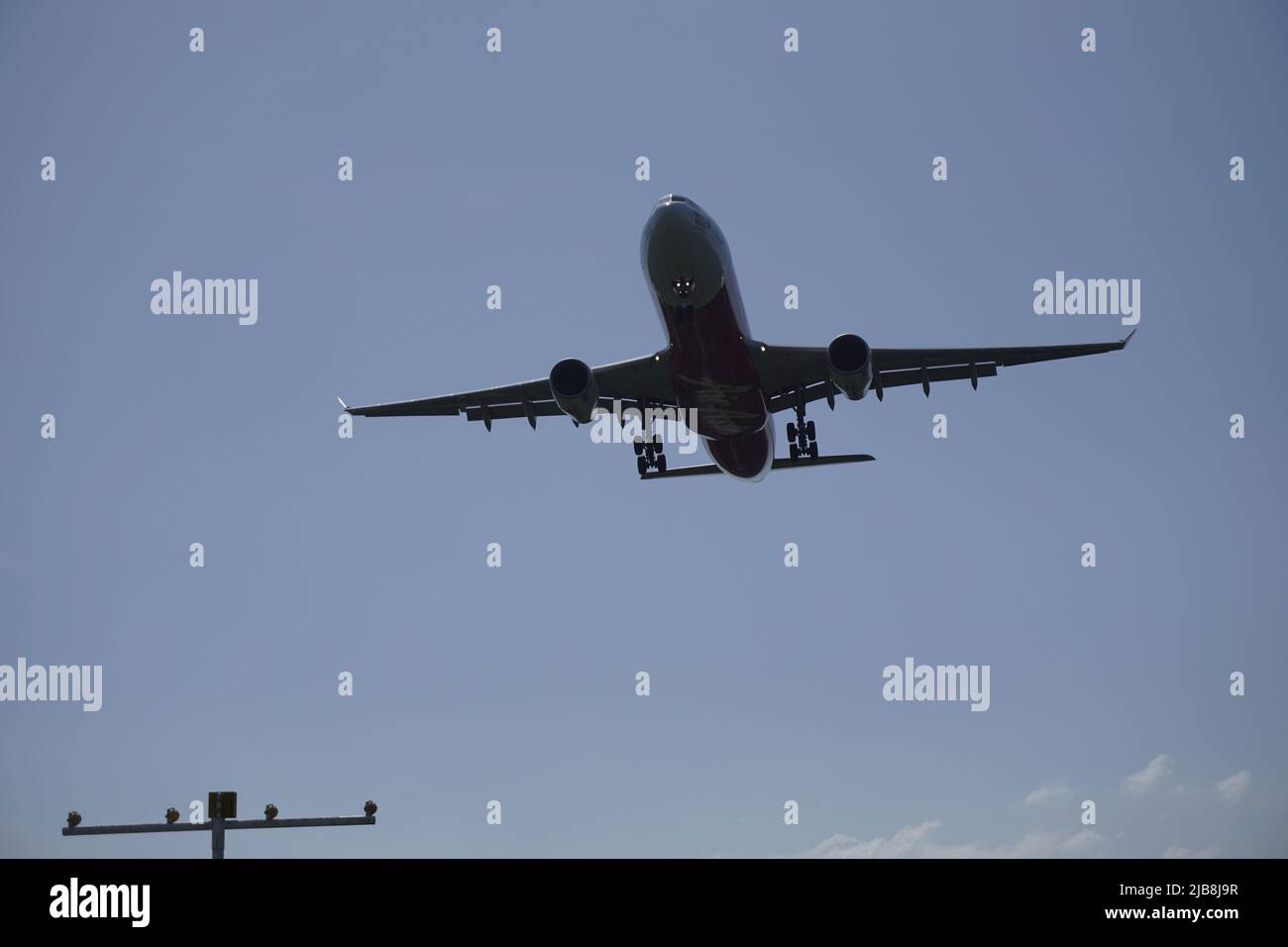 silhouette of airplane approaching runway Stock Photo