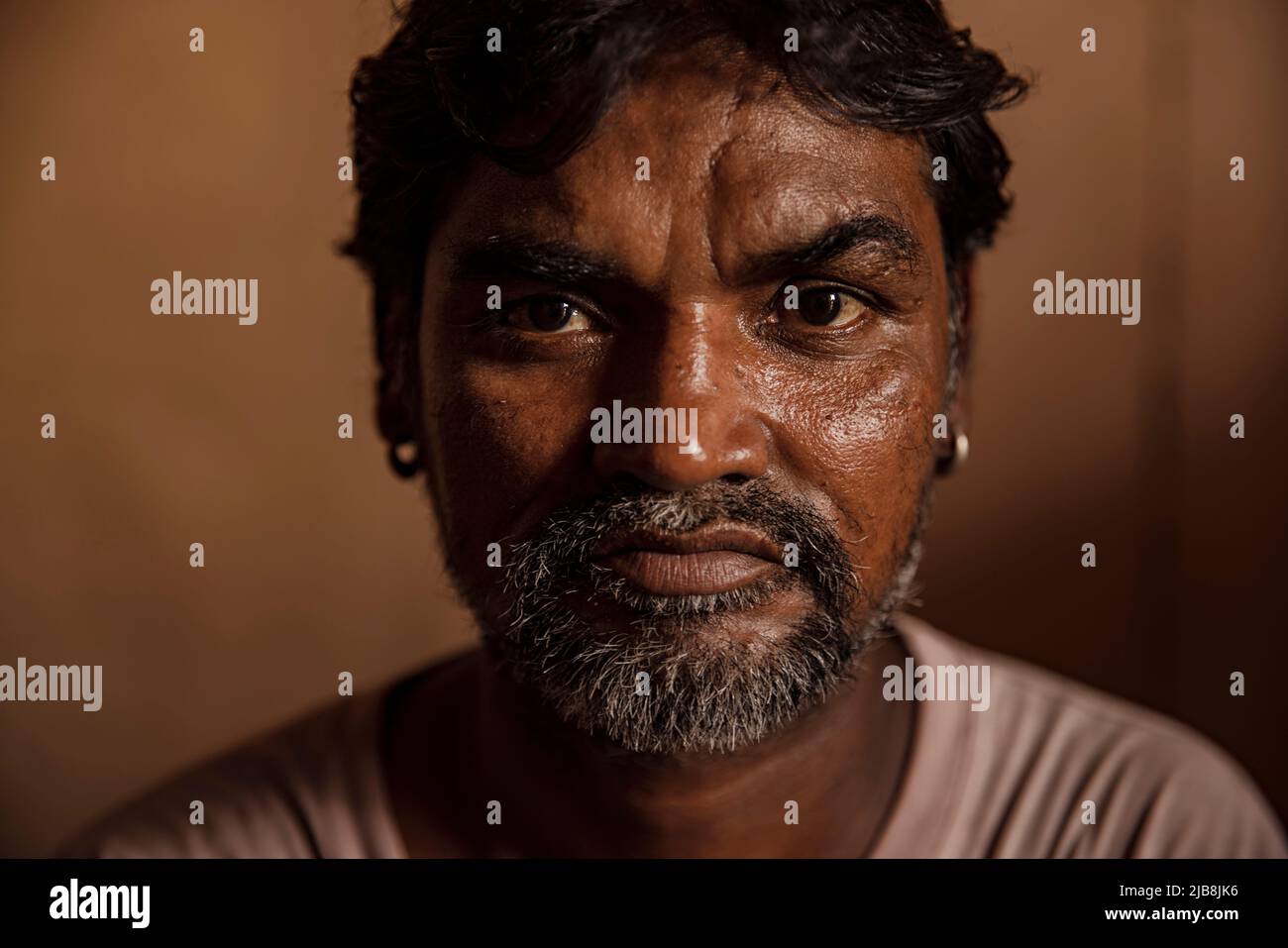 Portrait of a senior slum man at home Stock Photo