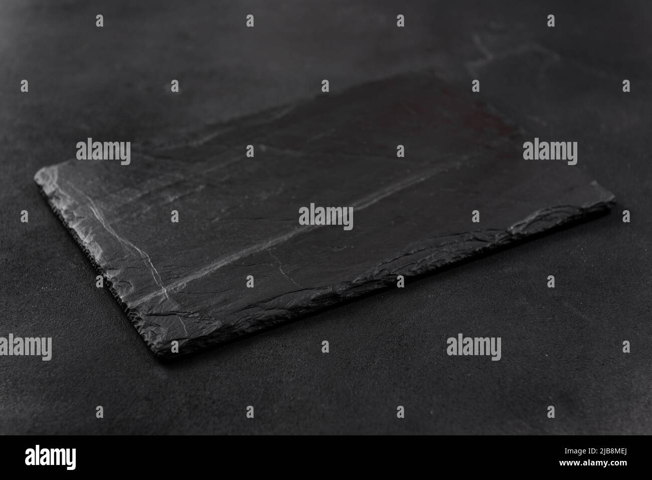 rectangular black cheese board on a dark background Stock Photo