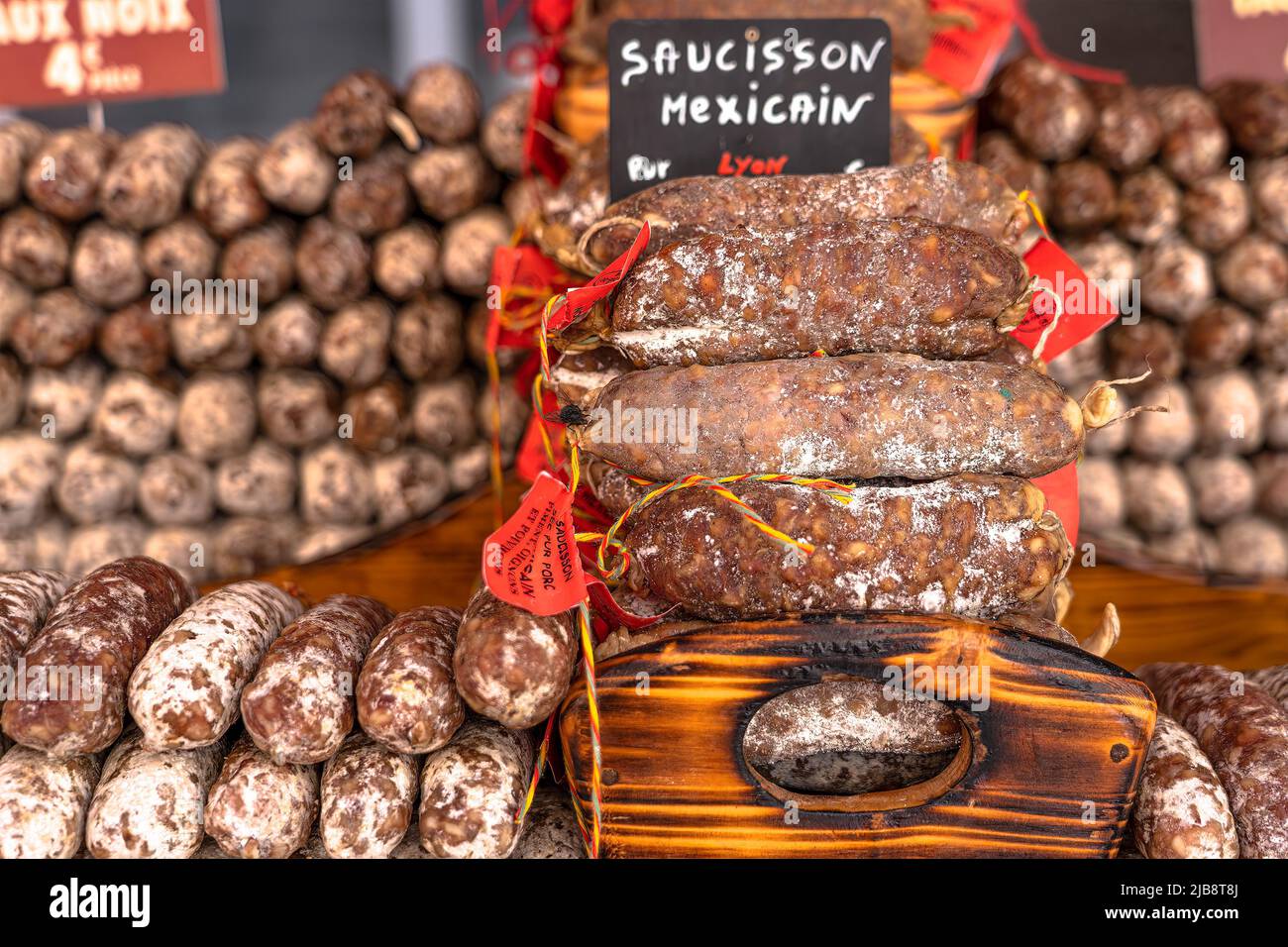 Stacks of various kinds of saucisson or saucisson sec - dry-cured sausages, typically made of pork, or a mixture of pork and other meats. Stock Photo