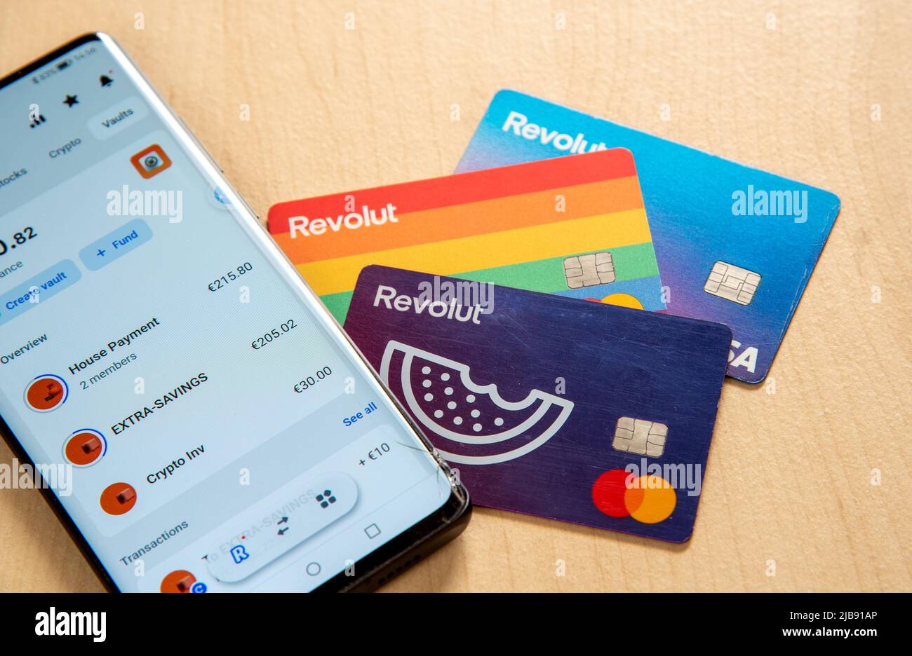 Smartphone revolut debit card. Mobile phone app cryptocurrency trading online banking Stock Photo