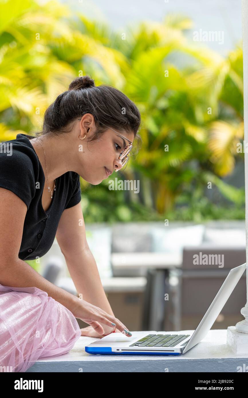 Portrait of latin young woman using laptop outdoors - stock photo Stock Photo