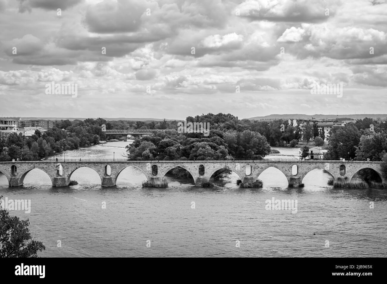 Zamora River with its Roman bridge and dramatic sky in a black and white image. Stock Photo