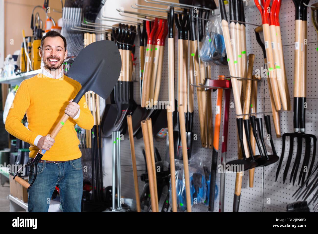 Man choosing new shovel in garden equipment shop Stock Photo Alamy