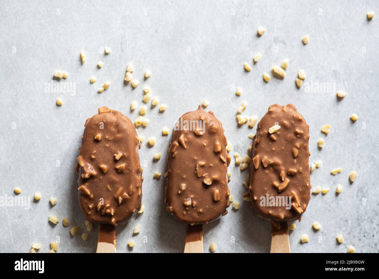 Three chocolate almond ice-cream on a wooden stick. Top view. Stock Photo