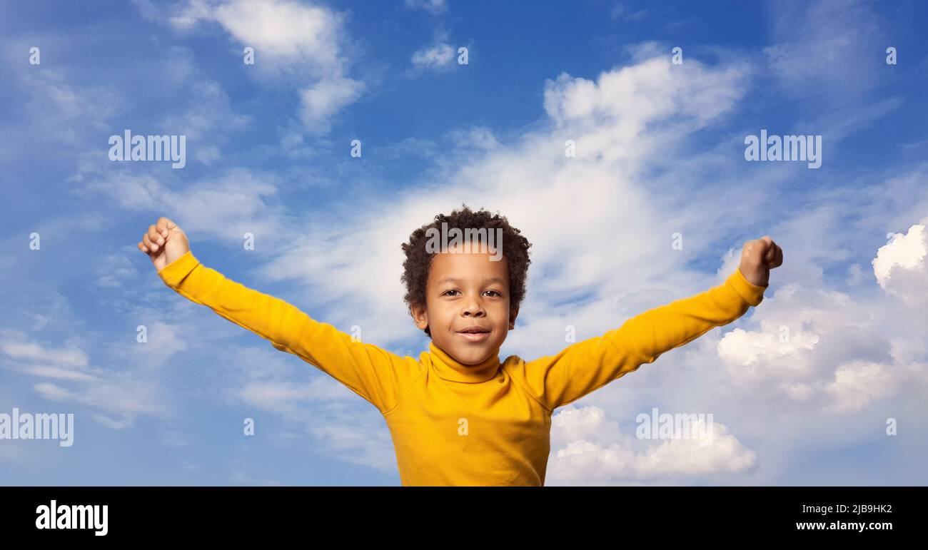 Cute happy African American kid boy on sky clouds background Stock Photo
