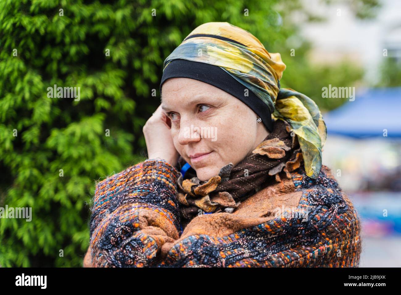 Vladivostok, Russia. 4th June, 2022. A craftswoman uses her plant-dyed headscarf to imitate the famous painting 'Girl with a Pearl Earring' on a street in Vladivostok, Russia, June 4, 2022. In order to protect and develop traditional Russian handicrafts, the city government of Vladivostok provides a free place for craftsmen to display and sell their homemade handicrafts in the city center. Credit: Guo Feizhou/Xinhua/Alamy Live News Stock Photo