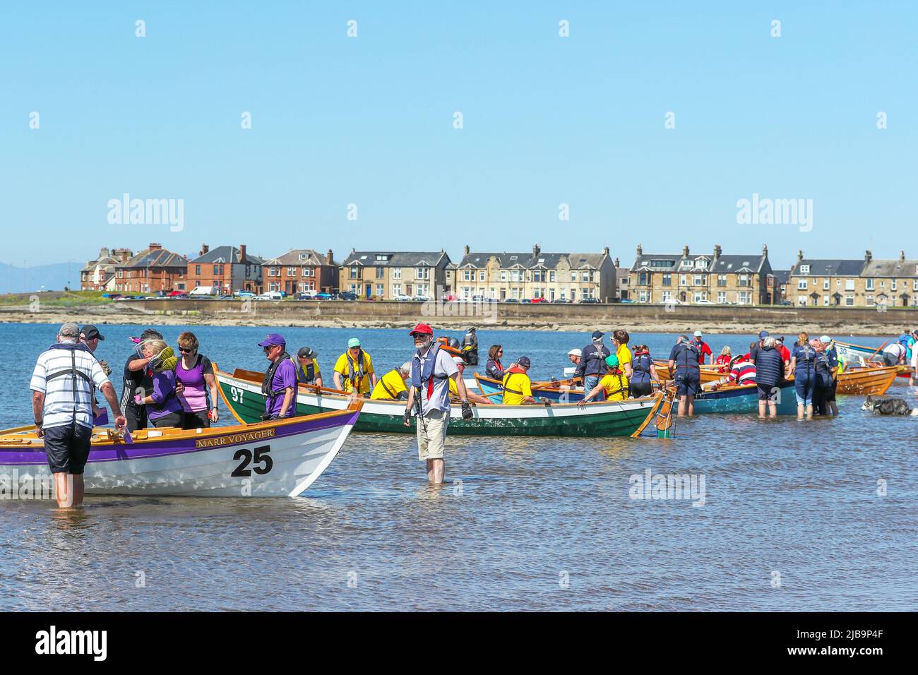 Troon, UK. 04th June, 2022. 04 June 2022. Troon, UK. Troon Coastal Rowing Club (TCRC) held its annual regatta on the Firth of Clyde sailing from south beach Troon, Ayrshire, UK. The small boats are traditional, hand crafted, wooden, 4 crew, fishing skiffs, based on a 300 year old design. The race requires the competitors to row a set course of not less than 2 kilometres, leaving from the shore and on return, a team member has to take a stick of Troon rock (confectionery} and run to the finish line with it. The event attracted competitors from various coastal rowing clubs across Scotland Stock Photo