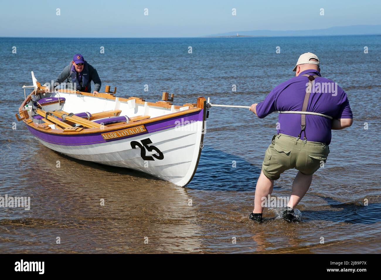 Troon, UK. 04th June, 2022. 04 June 2022. Troon, UK. Troon Coastal Rowing Club (TCRC) held its annual regatta on the Firth of Clyde sailing from south beach Troon, Ayrshire, UK. The small boats are traditional, hand crafted, wooden, 4 crew, fishing skiffs, based on a 300 year old design. The race requires the competitors to row a set course of not less than 2 kilometres, leaving from the shore and on return, a team member has to take a stick of Troon rock (confectionery} and run to the finish line with it. The event attracted competitors from various coastal rowing clubs across Scotland Stock Photo