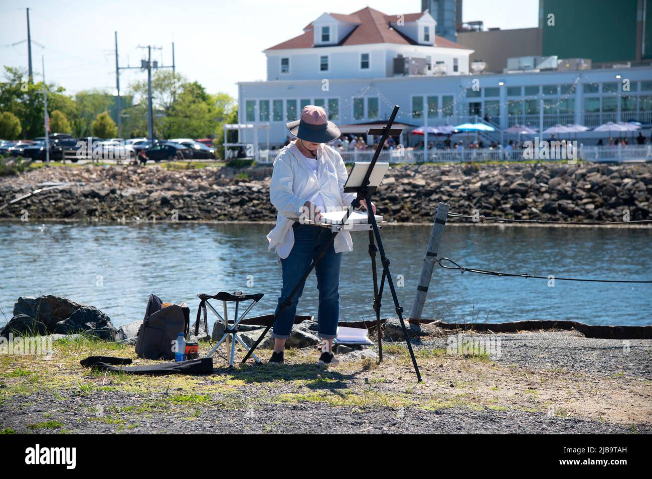 An artist painting in Sandwich, Massachusetts on Cape Cod next to the