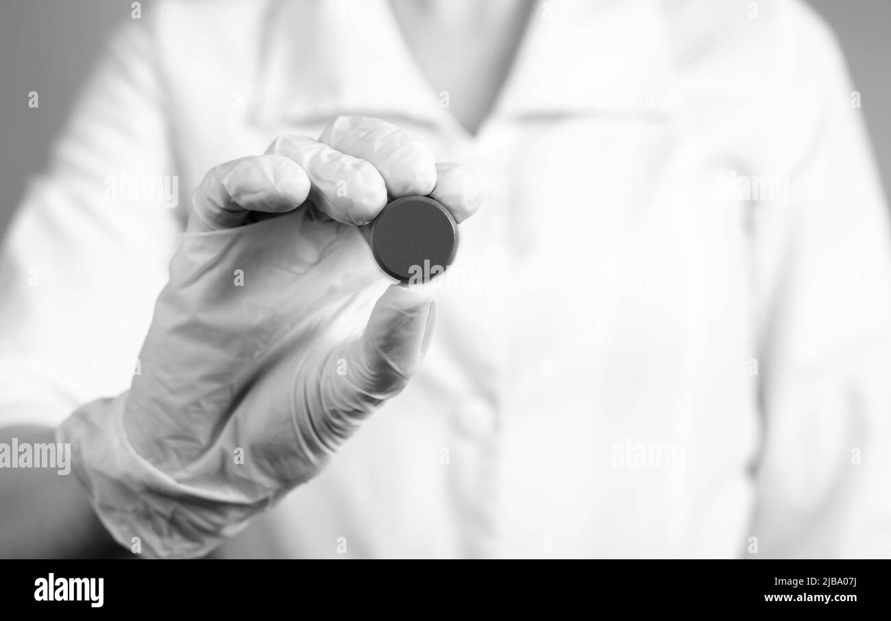 Doctor holding pill. Erroneous medication prescription, wrong dosage or medical decision, malpractice, tablets side effects concept. Black and white. High quality photo Stock Photo