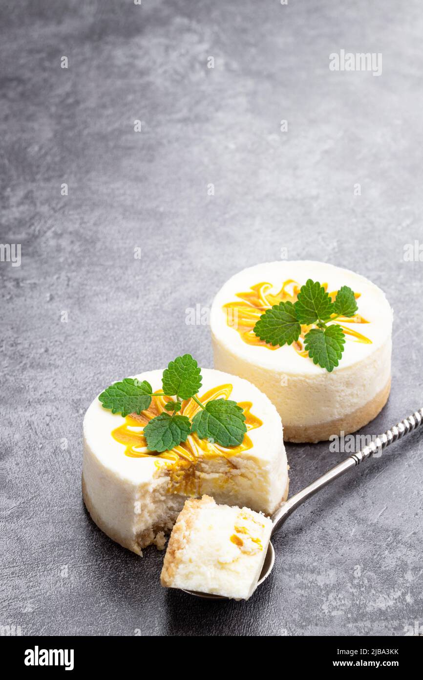 Mini  Cheesecakes decorated with yellow jam on gray background Stock Photo