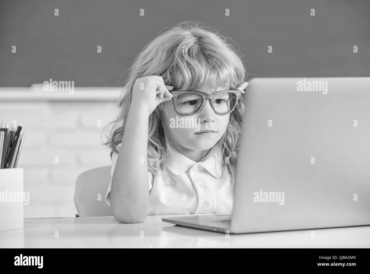 smart nerd kid in glasses with laptop. september 1. e-learning. child studying on computer. Stock Photo
