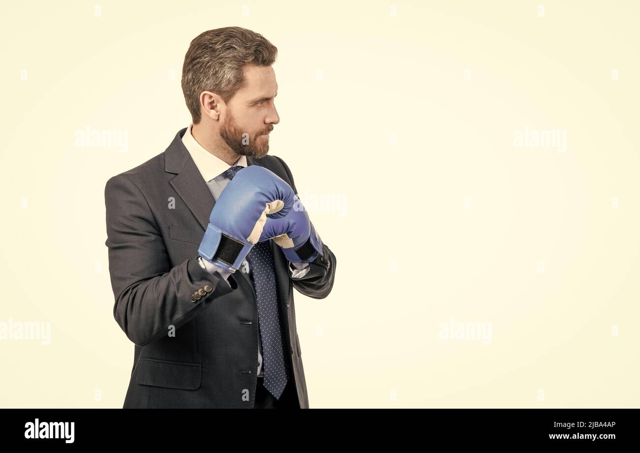 Serious professional man in boxing gloves and suit stand in fighting