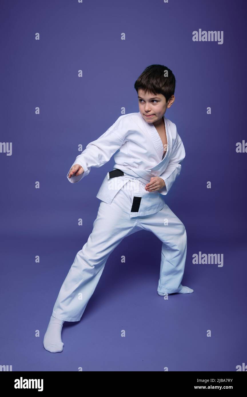 Oriental martial arts. Full length portrait of an aikido fighter, Caucasian 10 years old boy in