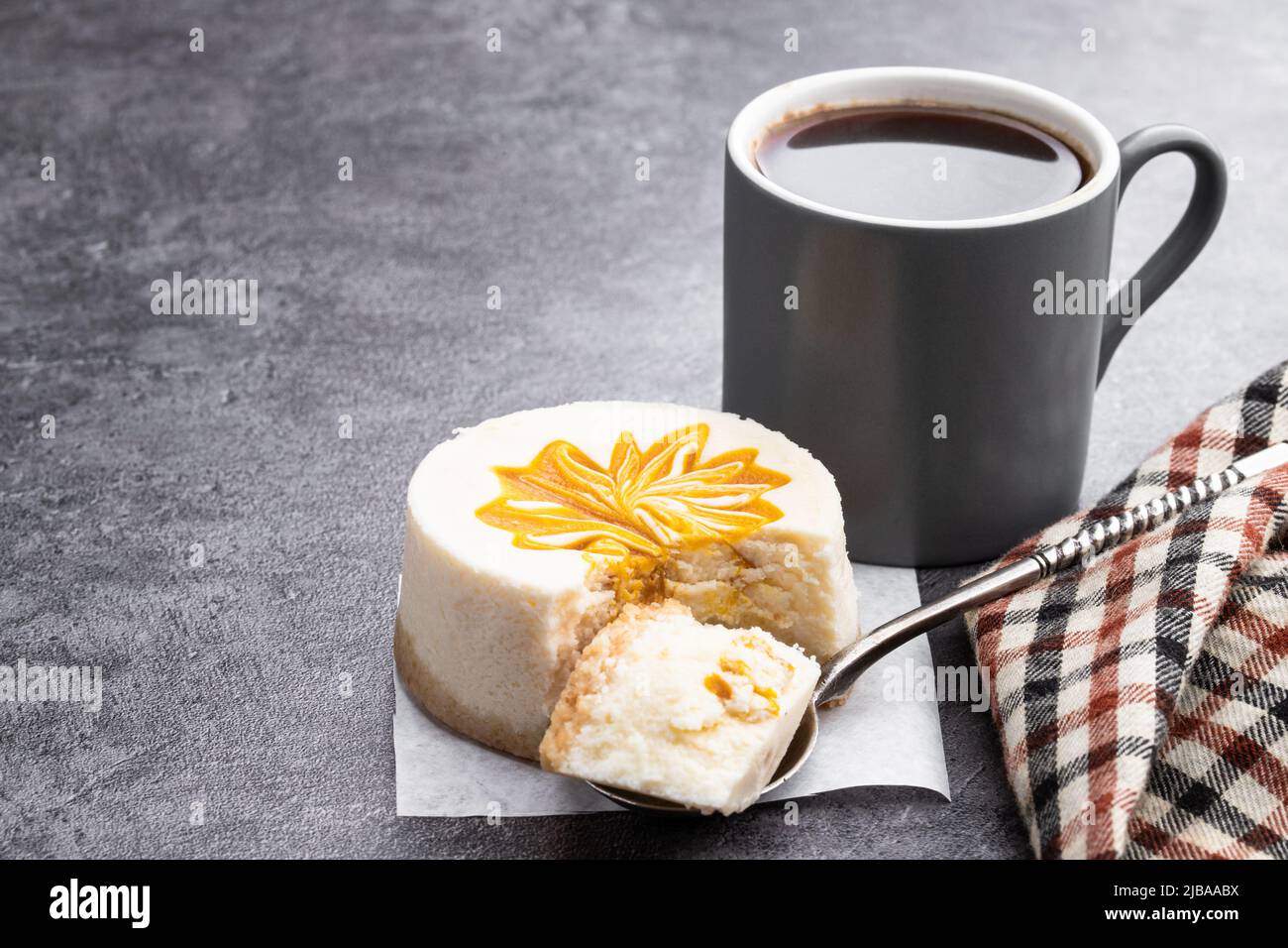 Mini  Cheesecakes decorated with yellow jam on gray background Stock Photo