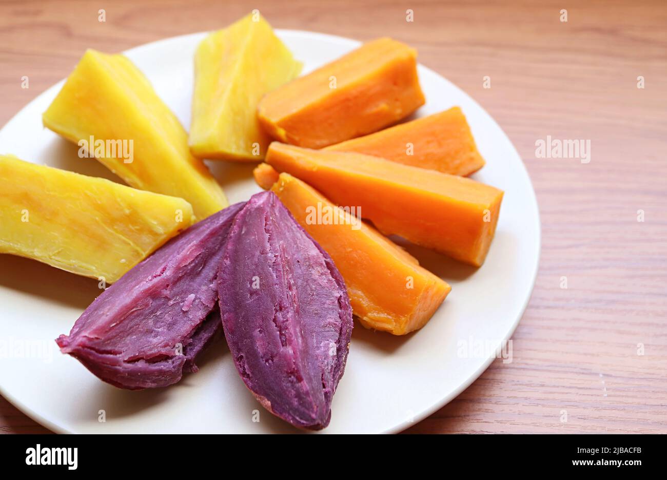 Plate of three different color steamed sweet potatoes, for a concept of good source of healthy carbs Stock Photo