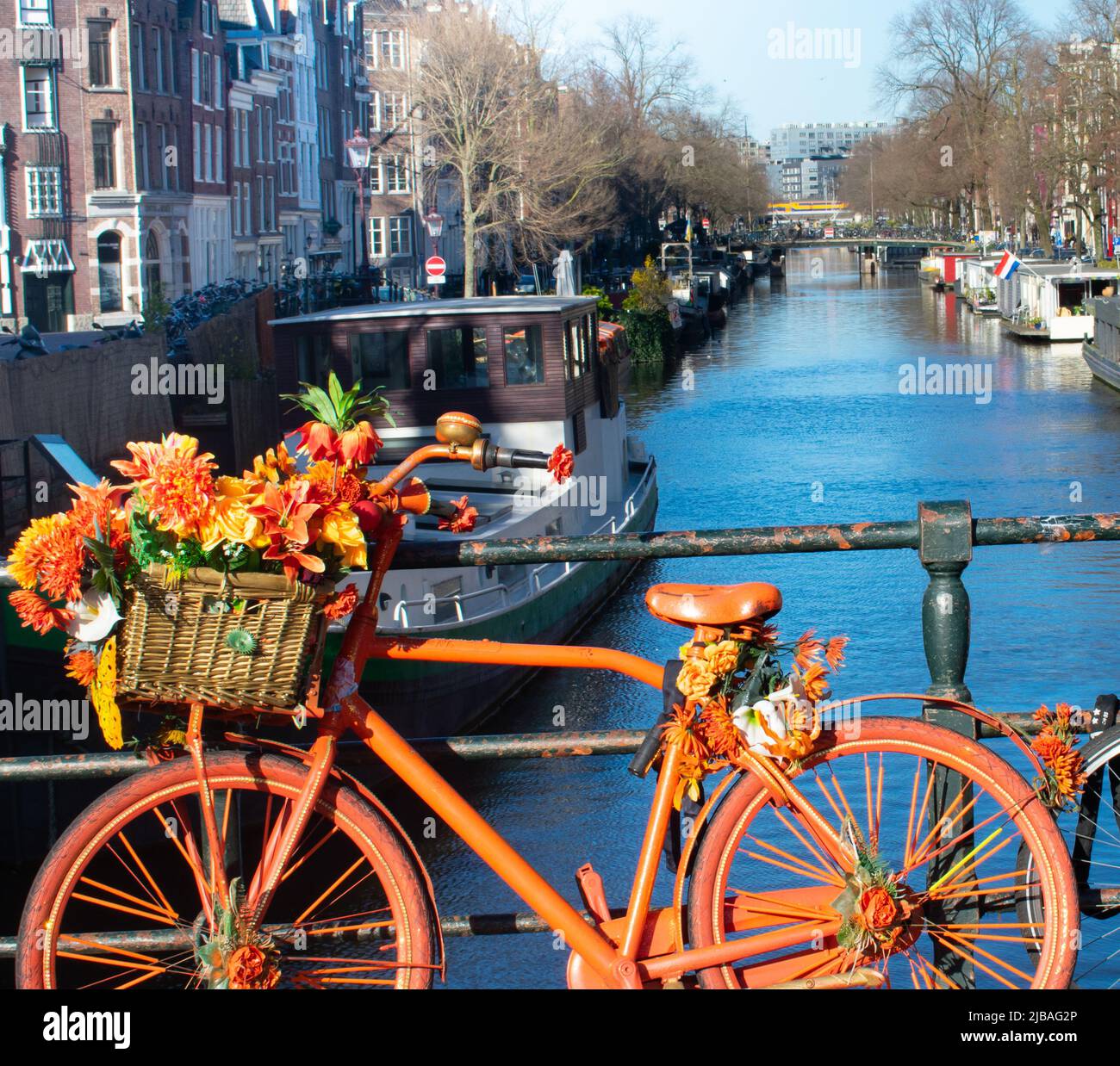 Amsterdam symbolic bright decorated bike with flowers and canal in