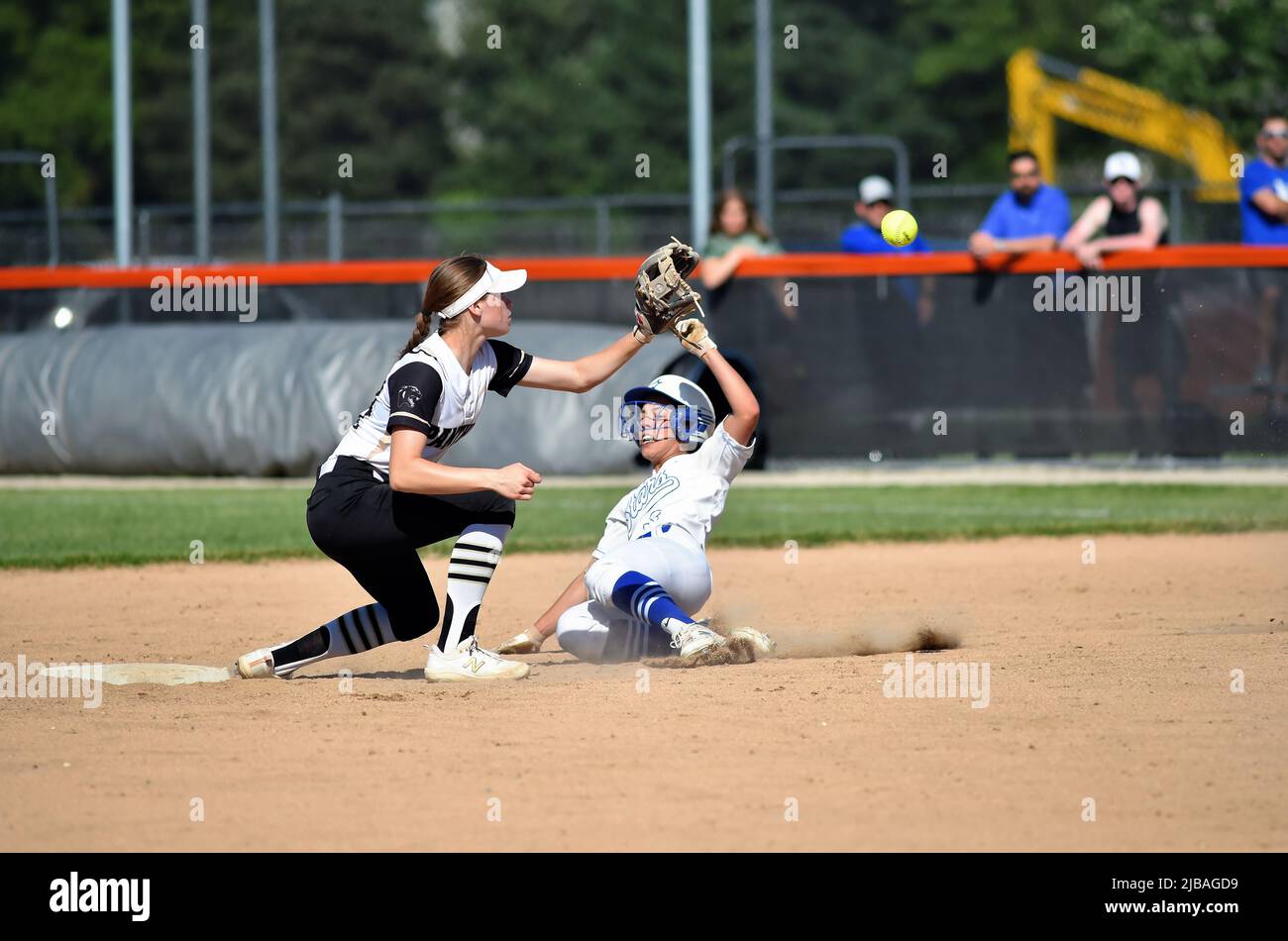 USA. Shortstop awaiting a throw from her catcher prior to applying a tag on an arriving baserunner who was attempting to steal second base. Stock Photo