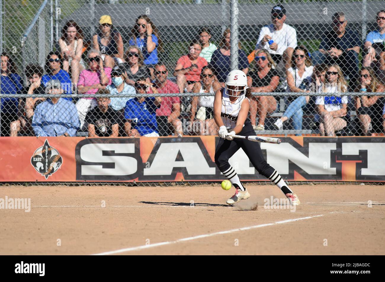 USA. Left-handed batter slapping an infield single to the left side of the infield. Stock Photo