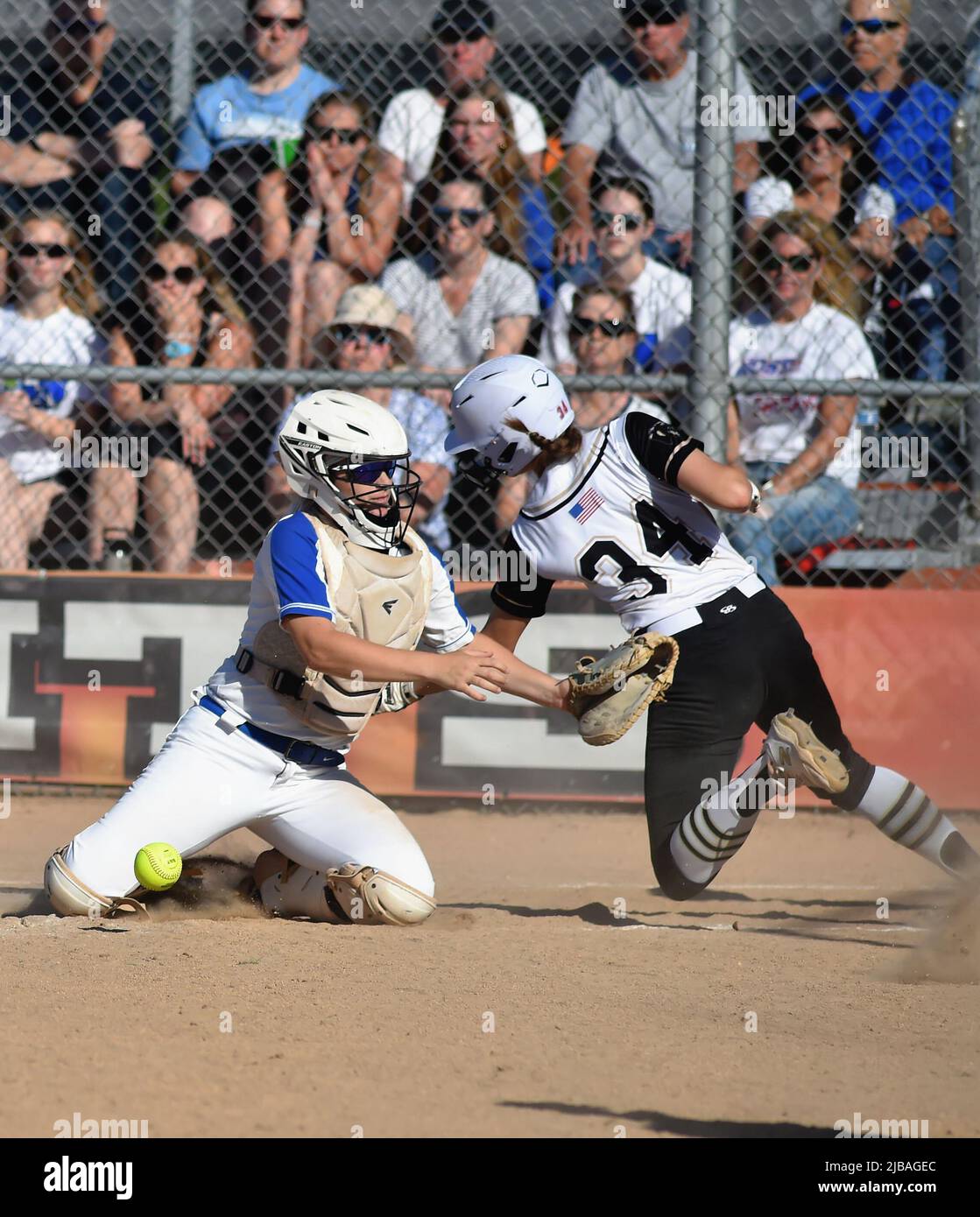 USA. Runner scoring as the opposing catcher was unable to secure the ball on a throw from the outfield prior to applying a tag. Stock Photo