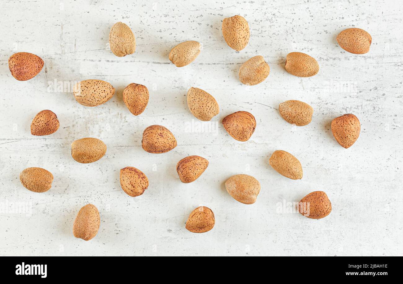 Top down view, whole almonds in shell on white stone board Stock Photo