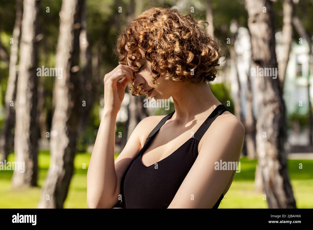 Beautiful redhead woman wearing black sports bra standing on city