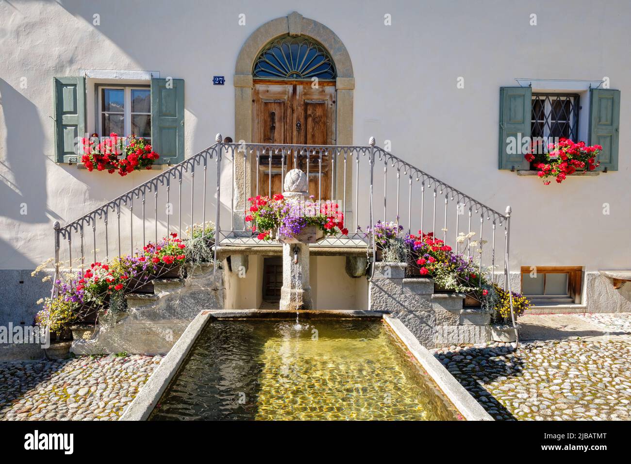 S-Chanf, Switzerland - September 24, 2022: Gorgeous, with flowers decorated water fountain located in the historic village center of S-Chanf (Grisons) Stock Photo