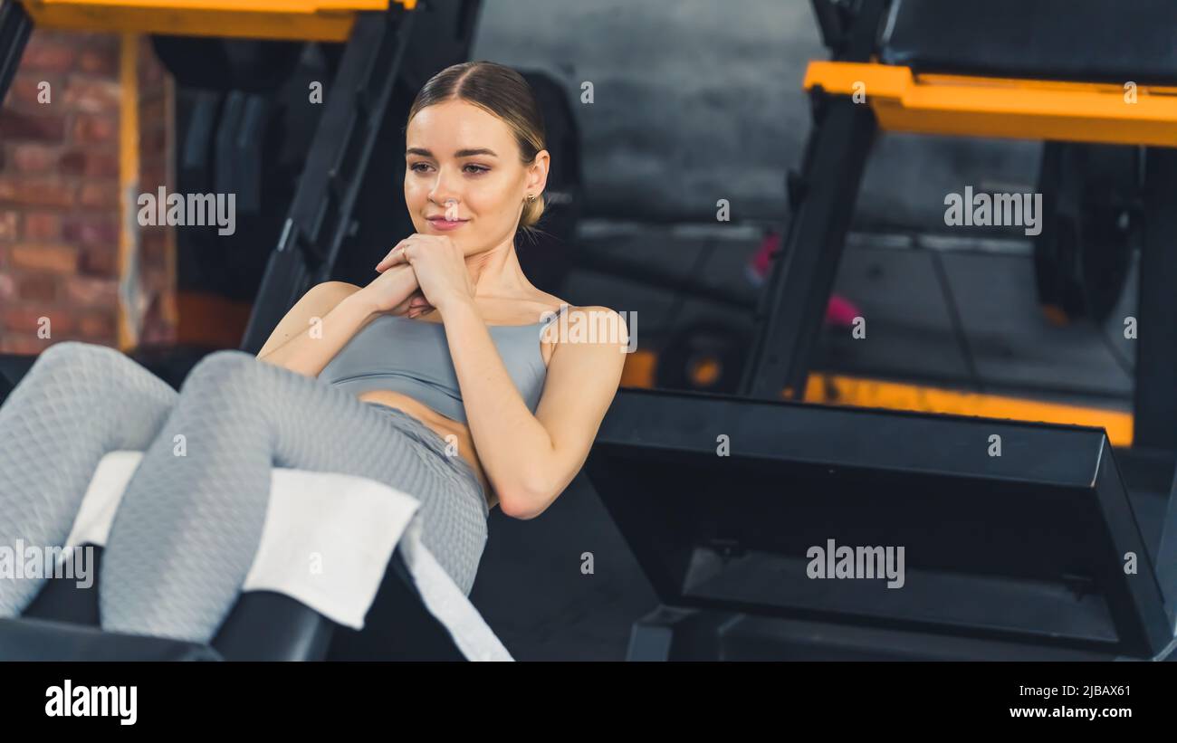 ABS exercise. Fit caucasian fashionable gym girl doing sit ups to train ...