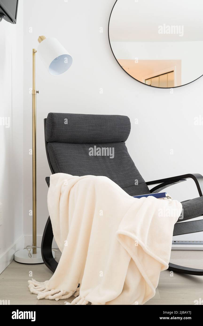 An easy chair with a blanket and book in a report Air BnB hotel unit. Stock Photo