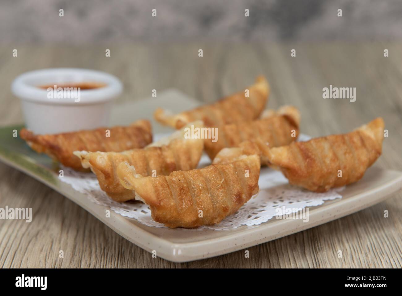 Asian cuisine deep fried crunchy gyoza with dipping sauce for a very hearty appetizer. Stock Photo