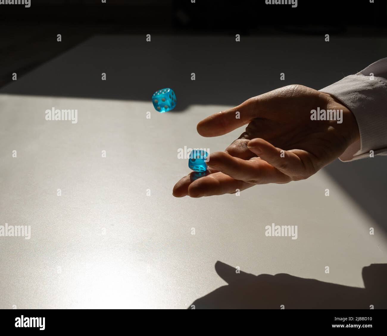 Woman throws a pair of blue transparent dice Stock Photo Alamy