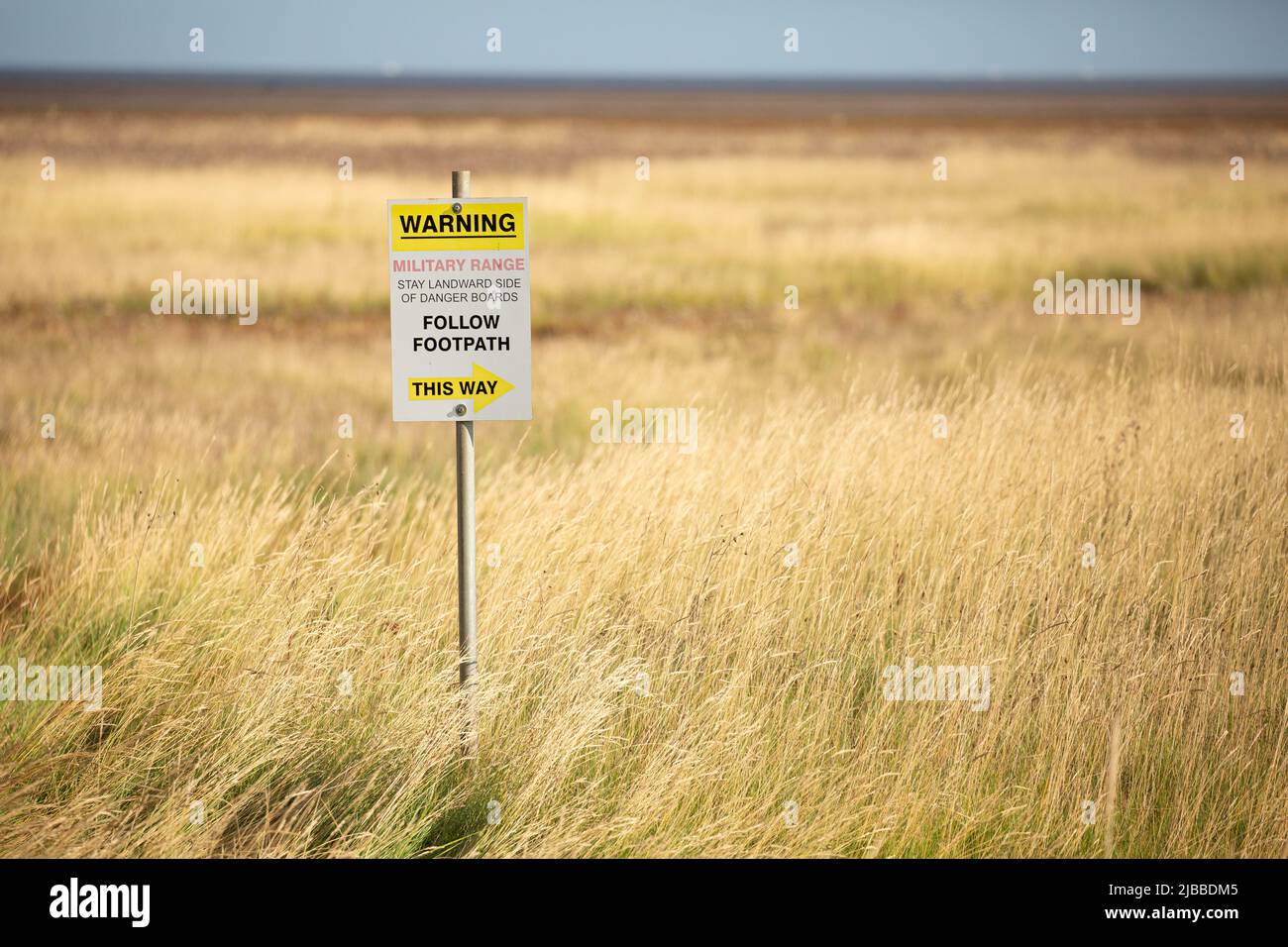 Danger, explosives sign in yellow grass at military firing range in ...