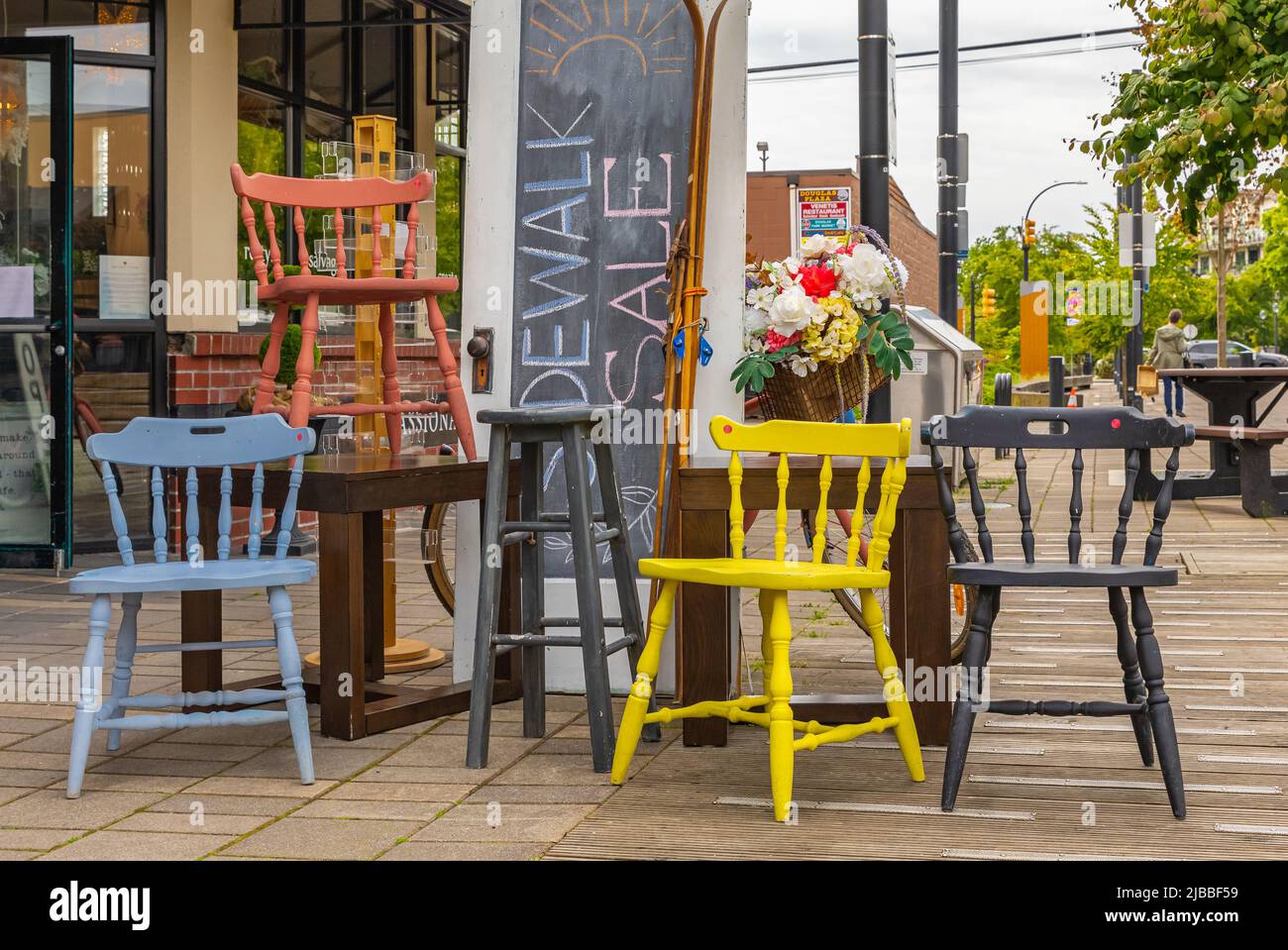 Vintage colorful wooden chairs on street flea market. Group of retro home wooden furniture on ...