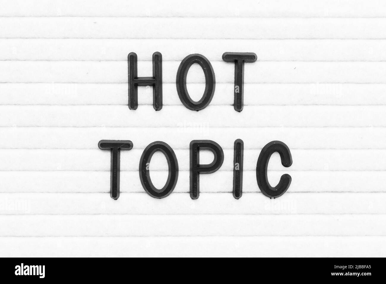 Black color letter in word hot topic on white felt board background