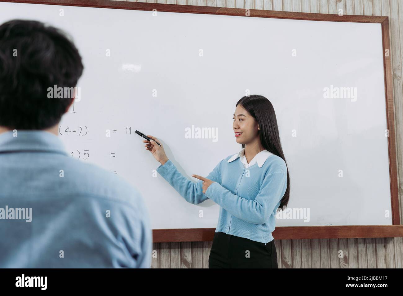 Young asian teacher teaching students at classroom Stock Photo - Alamy