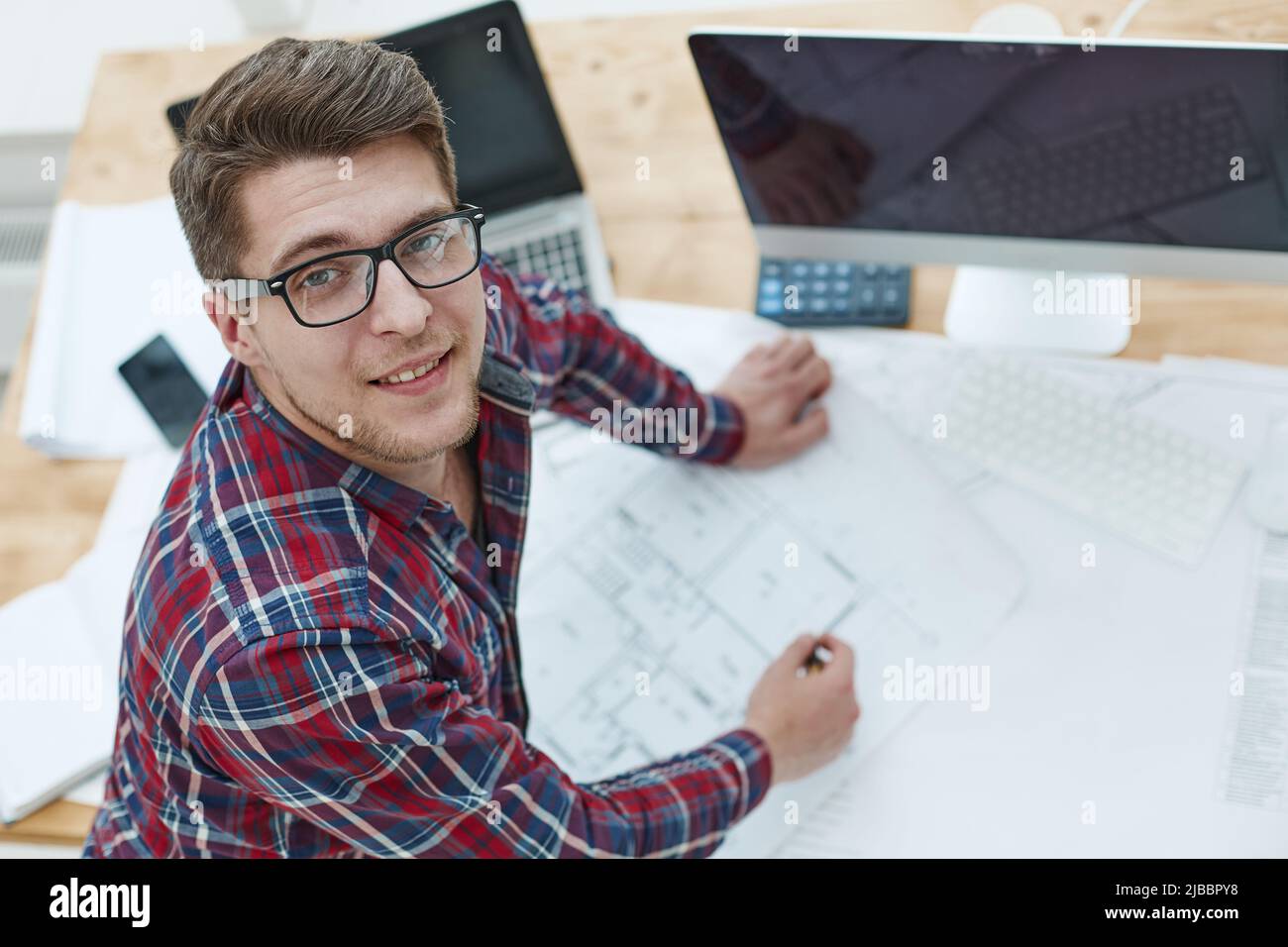 Architect working on drawing table in office Stock Photo