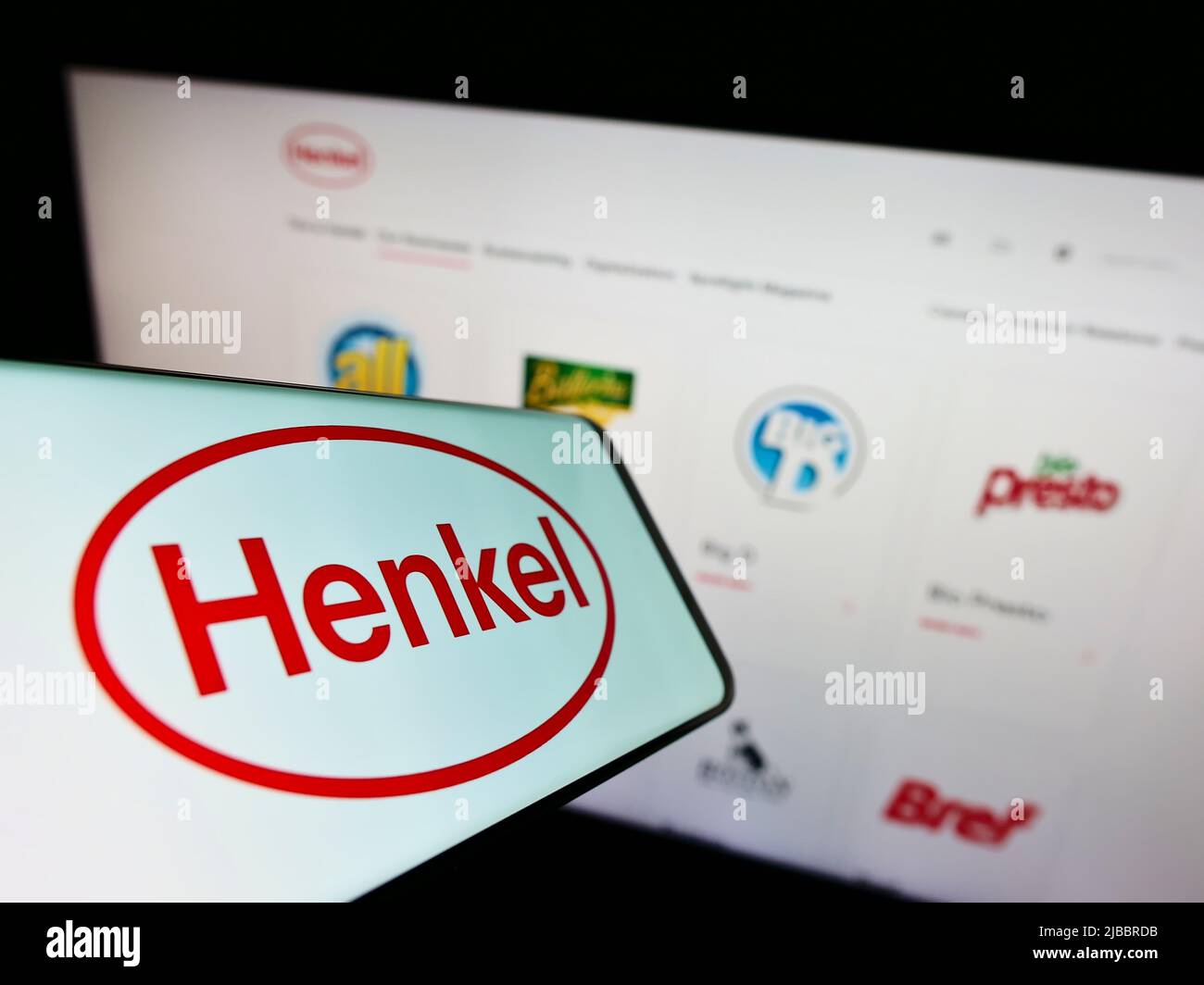 Smartphone with logo of consumer goods company Henkel AG Co. KGaA on screen in front of business website. Focus on center-right of phone display. Stock Photo