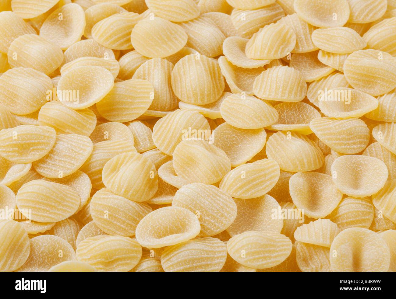 Uncooked orecchiette pasta background Stock Photo