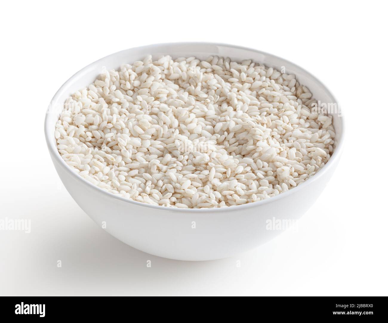 Uncooked arborio rice in white bowl isolated on white background with