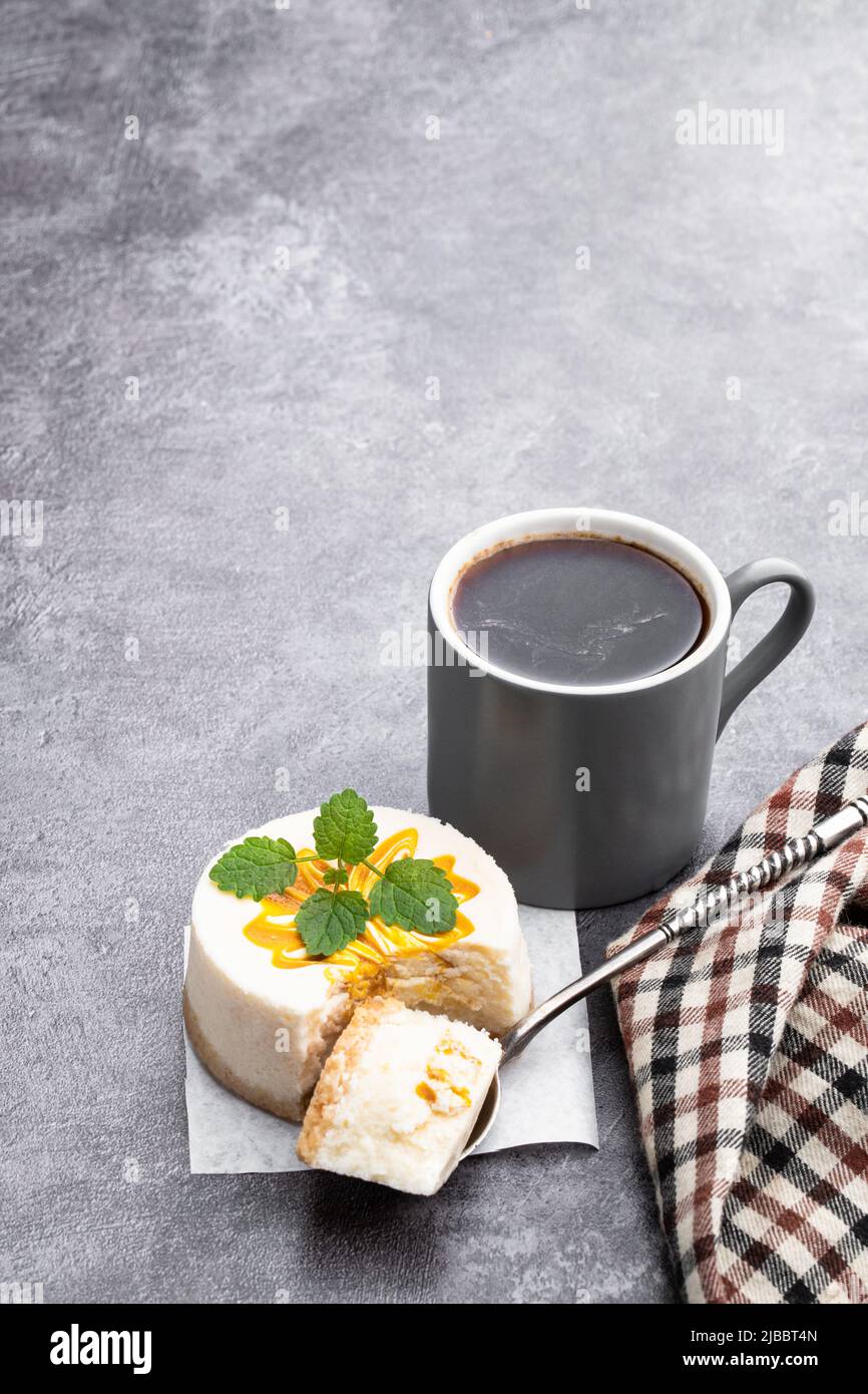 Mini Cheesecakes decorated with yellow jam on gray background Stock Photo
