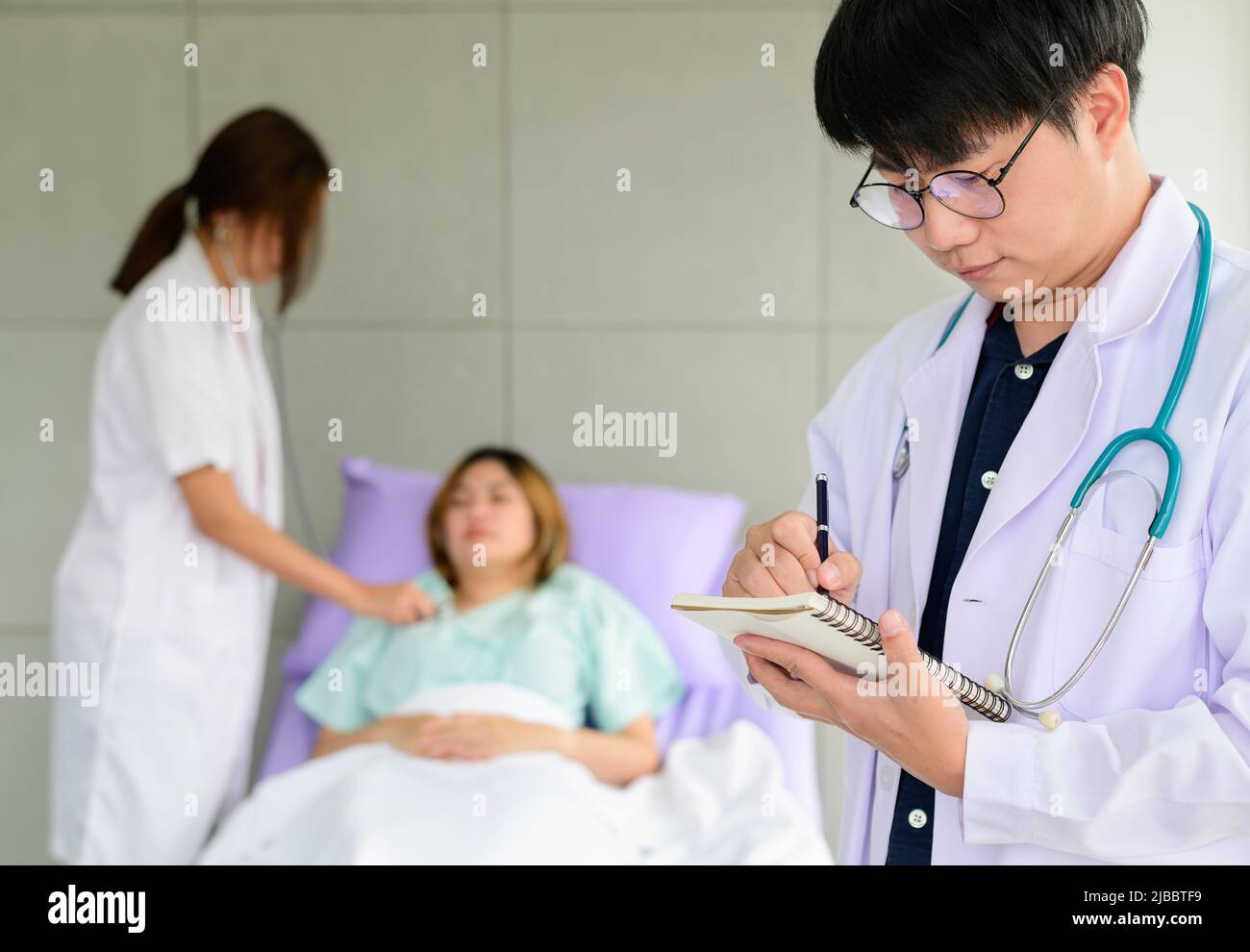Portrait asian doctor with his colleague and patient in the background Stock Photo