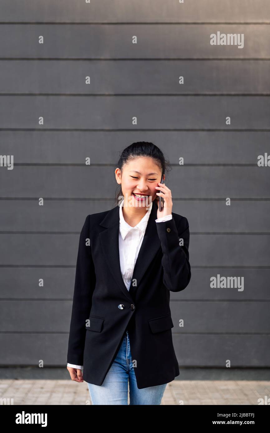 smiling asiatic businesswoman talking on the phone Stock Photo