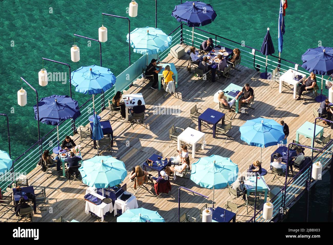 Sorrento, Italy - September 10 2021: Aerial view of people who enjoy a drink in  a beach club in Sorrento in the bay of Napoli in Italy. Stock Photo