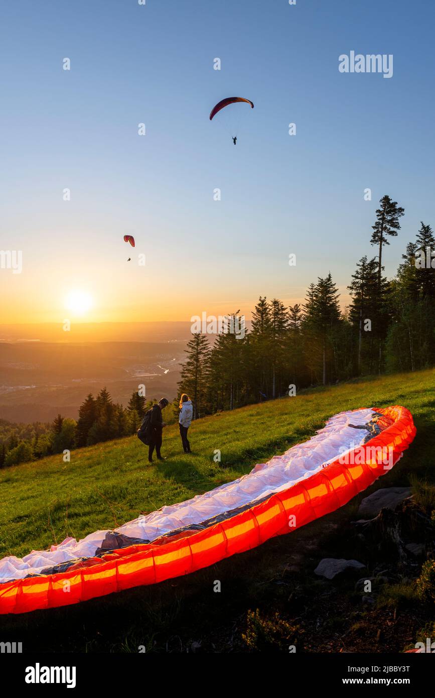 Paraglider at the take-off site at the Devil's mill in the Murg valley in the Black Forest spreads his paraglider against the sunset, Germany Stock Photo